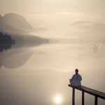 Gambar Manusia Meditasi Yoga di Tepi Danau pada sore hari.